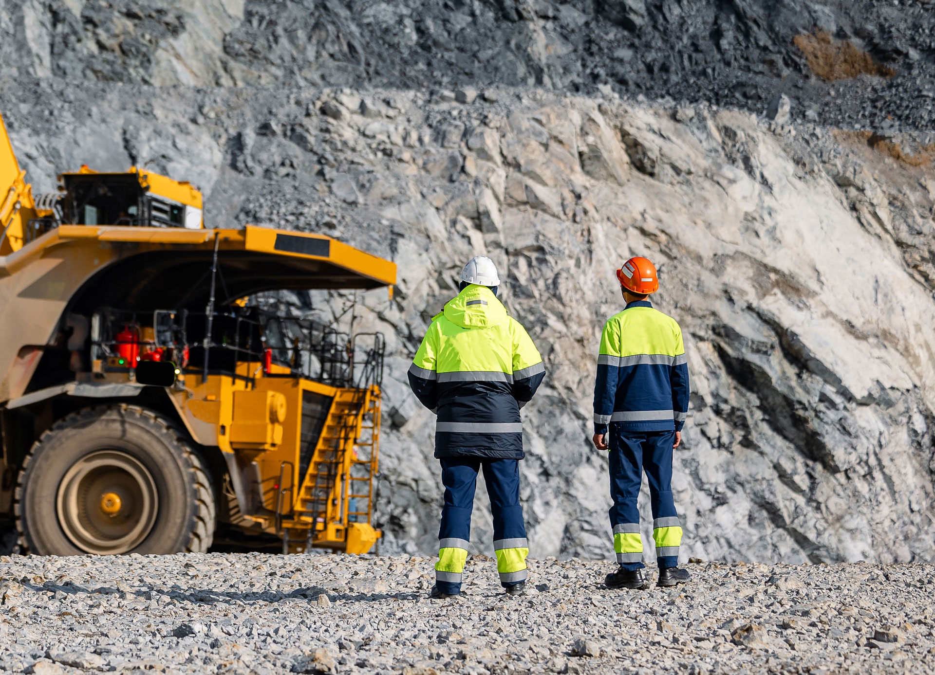 Two men standing next tot a mining truck